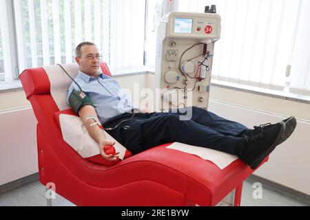 Erfurt, Deutschland. 24. Juli 2023. Spender Patrick Kanzler liegt während einer Plasmaspende im Blutspendezentrum Hama auf einer Couch. Darüber hinaus werden Informationen über die Bedeutung von Blut- und Plasmaspenden bereitgestellt. Kredit: Bodo Schackow/dpa/Alamy Live News Stockfoto