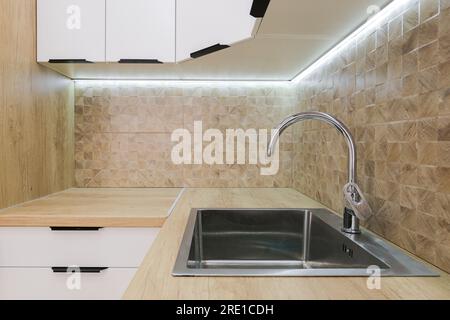 Wasserhahn und Waschbecken aus Stahl in der Küche Stockfoto