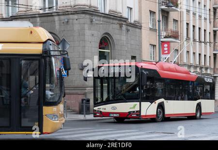 Zwei Busse fahren an einer Straße im Zentrum von Vilnius, Litauen vorbei. Öffentlicher Verkehr VVT (Vilniaus viešasis transportas) Stockfoto