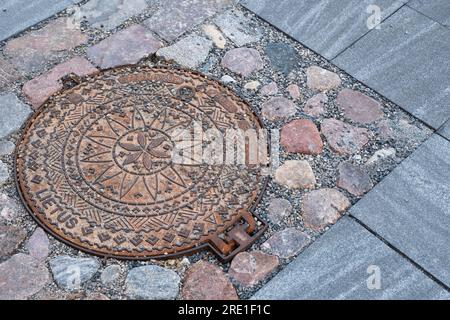 Dekorierter Schachtdeckel in einer Straße in der litauischen Stadt Kaunas Stockfoto