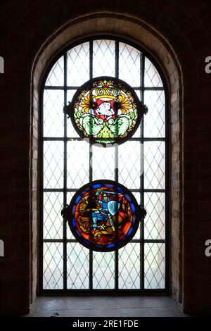 Bogenfenster in der Burgmauer mit zwei runden Buntglasfenstern im Schloss Trakai in Litauen Stockfoto