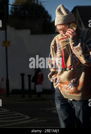 Mann auf Handy bei Sonnenlicht Stockfoto