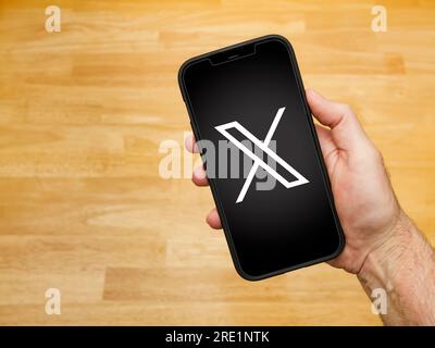 ATLANTA, GEORGIA - 24. JULI 2023 : Elon Musk hat das Twitter-Logo in X. Mann mit Handy und neuem Twitter X-Logo umbenannt. Stockfoto