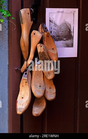 Viele Vorlagen für Schuhe aus Holz hängen außerhalb der Schuhmacherwerkstatt Stockfoto