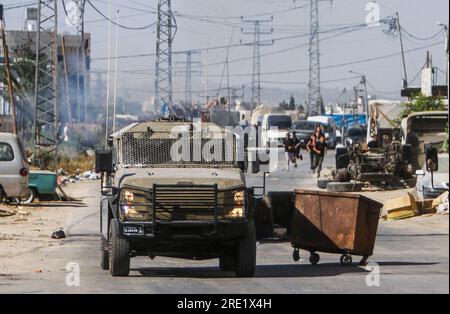 Nalus, Palästina. 24. Juli 2023. Die Palästinenser werfen während einer Militäroperation im Lager östlich von Nablus im besetzten Westjordanland Steine auf die gepanzerten Fahrzeuge des israelischen Militärs. Die israelische Armee hat während einer gemeinsamen Operation zur gleichzeitigen Verhaftung gesuchter Personen die Nour Shams-Lager östlich von Tulkarm und Aqabat Jabr in Jericho, Askar, östlich von Nablus überfallen. Kredit: SOPA Images Limited/Alamy Live News Stockfoto