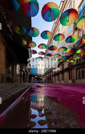 R. Nova do Carvalho Purple Street mit Sonnenschirmen. Chiado-Viertel, Partyviertel, in Lissabon, Portugal. Leere Menschen, schöne alte Straße mit Historiker Stockfoto