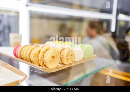 Sortiment bunte Makronen auf Cafe präsentieren. Vielzahl von Macaron Aromen. Süße Mandel Kuchen in speichern. Stockfoto