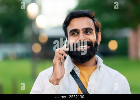 Ein Junger Indianer, Der Mit Dem Handy In Der Stadt Spaziert Stockfoto