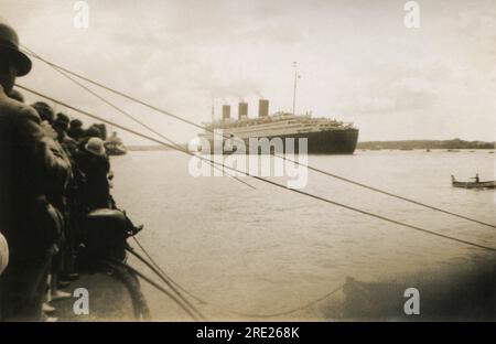 Southampton, Hampshire. c.1938 – am Kai versammeln sich Menschenmassen, um dem transatlantischen Passagierschiff der Cunard-White Star Line, RMS Queen Mary, beim Auslaufen aus den Southampton Docks mit Schleppbooten zuzusehen. Das Schiff wurde von John Brown & Company in Clydebank, Schottland, gebaut und segelte auf ihrer Jungfernfahrt am 27. Mai 1936. Abgesehen von einer Zeit während des Zweiten Weltkriegs, als sie konvertiert und als Truppenschiff angestellt wurde, blieb sie bis 1967 im Dienst. Sie gewann den Blue Riband-Preis für die schnellste transatlantische Überquerung im August 1936 und dann erneut im Jahr 1938, wobei sie ihn bis 1952 behalten hat. Stockfoto