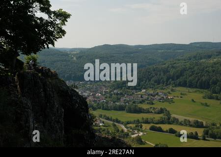 Eine beeindruckende Aussicht von einer Klippe auf eine charmante kleine Stadt in Deutschland, die ein Gefühl des ruhigen ländlichen Lebens einschließt. Stockfoto