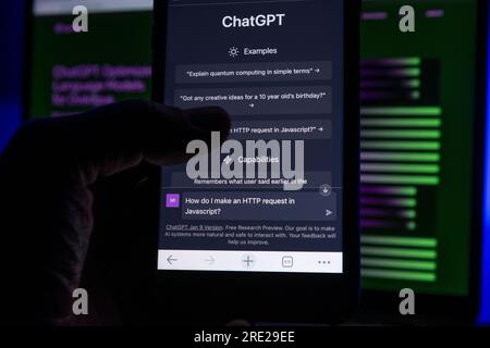 Azoren, Portugal - 16.01.2023: Hält das Mobiltelefon mit der ChatGPT Prompt-Webseite in der Hand und verwischt im Hintergrund die AI ChatGPT-Homepage auf einem Laptop. Stockfoto