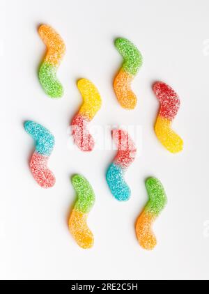 Mehrfarbige Gummis in Zucker auf weißem Hintergrund, Draufsicht. Gelee, Marmelade-Süßigkeiten. Stockfoto