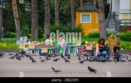 Kasachstan, Almaty. Taubenfütterung vor der Ascension Cathedral, Panfilov Guardsmen Park. Stockfoto