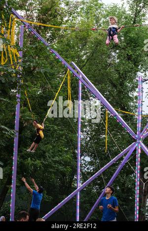 Kasachstan, Almaty. Kok-Tobe-Park. Junge Jungen und Mädchen schweben in der Luft an elastischen Seilen. Stockfoto