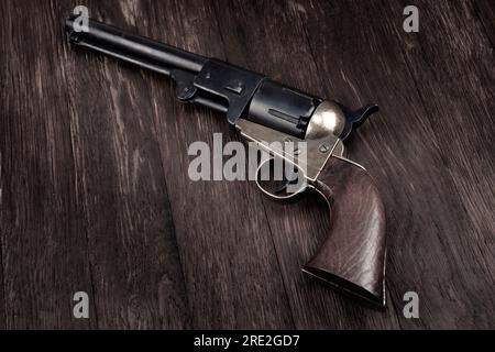 Antiker amerikanischer Perkussionsrevolver im alten Westen auf Holzterrasse Stockfoto