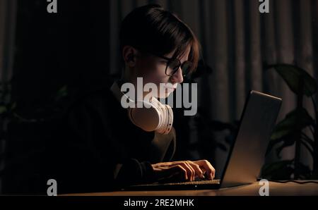 Spielsucht bei Videospielen. Ein konzentrierter Teenager spielt ein Videospiel, eport, virtuellen Wettkampf auf der Maus mit Tastatur im Dunkeln Stockfoto