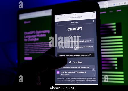 Azoren, Portugal - 16.01.2023: Smartphone-Bildschirm mit ChatGPT-Eingabeaufforderung und im Hintergrund verschwommen die AI ChatGPT-Homepage auf einem Laptop. Deve Stockfoto