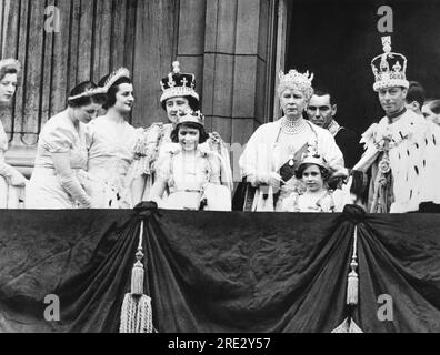 London, England: 12. Mai, 1937 King George VI. Und Queen Elizabeth am Krönungstag auf dem Balkon des Buckingham Palace. In der Mitte befindet sich Queen Mary und vorne sind Prinzessin Elizabeth (links) und Prinzessin Margaret Rose, deren übergroße Krone von König George aufgehalten wird. Rechts von Königin Elizabeth ist Lady Ursula Manners, eine ihrer sechs Ausbilder. Stockfoto