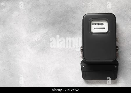 Stromzähler an hellgrauer Wand, Platz für Text Stockfoto