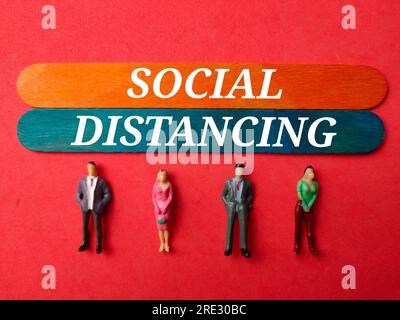 Miniaturmenschen mit dem Wort SOZIALE DISTANZ. Geschäftskonzept. Stockfoto