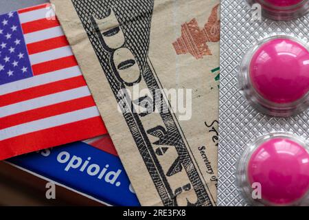 Ein Opioid-Suchtbegriff mit Dollarschein, amerikanischer Flagge und dem Wort Opioid auf einer Medikamentenpackung. Stockfoto