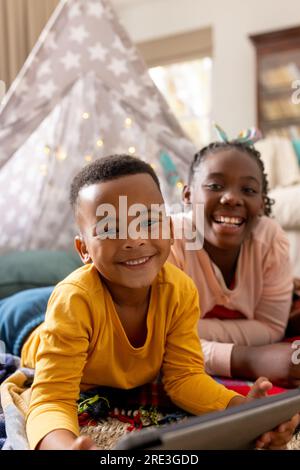Porträt glücklicher afroamerikanischer Bruder und Schwester mit Tablet zu Hause Stockfoto