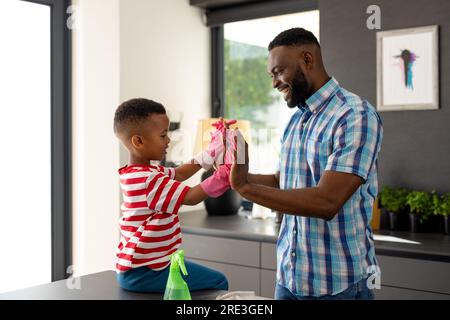 Glücklicher afroamerikanischer Vater und Sohn High Five in der Küche zu Hause Stockfoto