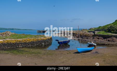 Blick über den felsigen Hafen zum alten Anleger und einigen kleinen Booten in Portencross in Seamill West Kilbride an einem hellen Sommertag im Juni mit blu Stockfoto