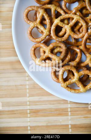 Salzige, köstliche Brezel auf einem weißen Teeteller. Gesundes Essen. Stockfoto