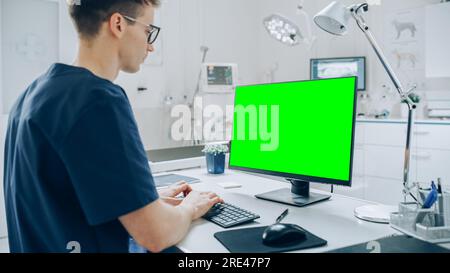 Weibliche und männliche Veterinäre, die Gesundheitsuntersuchungen auf einem Haustier durchführen. Fachtierarzt in einer modernen Veterinärklinik mit Green Screen Monitoren Stockfoto