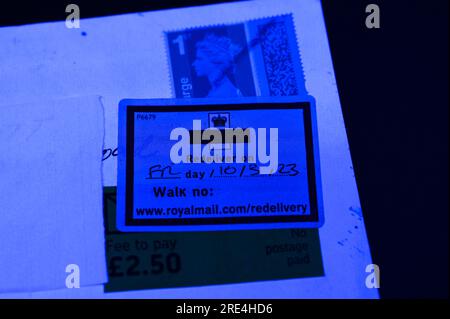 England, 25. Juli 2023: Wenn ein gefälschter Royal Mail-Stempel per Post entdeckt wird, wird er zurückgehalten, bis der Empfänger eine Gebühr bezahlt, da er als „kein Porto bezahlt“ vermerkt ist. - Gefälschte Royal Mail-Strichcodes werden auf eBay zu einem Bruchteil des Originalpreises verkauft. Bögen mit 50 Briefmarken werden ab 15 Pfund (GBP) verkauft und sehen für den ahnungslosen Blick echt aus. Unter UV-Licht sind jedoch kleine Unterschiede zu erkennen. Kredit: Stop Press Media/Alamy Live News Stockfoto