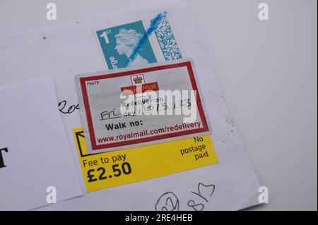 England, 25. Juli 2023: Wenn ein gefälschter Royal Mail-Stempel per Post entdeckt wird, wird er zurückgehalten, bis der Empfänger eine Gebühr bezahlt, da er als „kein Porto bezahlt“ vermerkt ist. - Gefälschte Royal Mail-Strichcodes werden auf eBay zu einem Bruchteil des Originalpreises verkauft. Bögen mit 50 Briefmarken werden ab 15 Pfund (GBP) verkauft und sehen für den ahnungslosen Blick echt aus. Unter UV-Licht sind jedoch kleine Unterschiede zu erkennen. Kredit: Stop Press Media/Alamy Live News Stockfoto