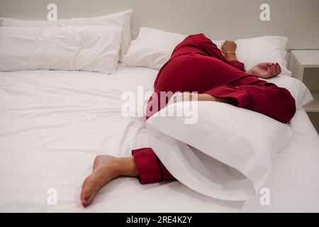 Nicht erkennbare erschöpfte ältere Frau, die im Bett liegt und an Kopfschmerzen oder Migräne leidet, sich unwohl fühlt, an Schlaflosigkeit leidet, Schlafmangel. Mangel o Stockfoto
