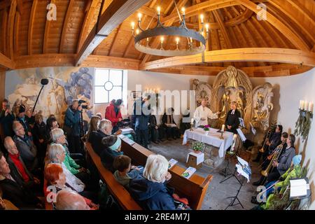 Garmisch Partenkirchen, Deutschland. 25. Juli 2023. Der katholische Priester Florian Hammerl (l) und der protestantische Priester Uli Wilhelm (r) halten in der Mariä Heimsuchung-Kapelle ein ökumenisches Requiem für den Zugspitze-Gletscher. Zusätzlich zu Informationen und Gebeten wird der Gletscher gesegnet und ein für den Anlass zusammengestelltes Bergquiem wird mit drei Sängern und einem Windchor Premiere erhalten. Kredit: Peter Kneffel/dpa/Alamy Live News Stockfoto