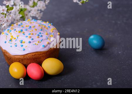 Frisch gebackenes hausgemachtes Osterbrot, natürlich gefärbte Eier und Frühlingsblumen. Stockfoto