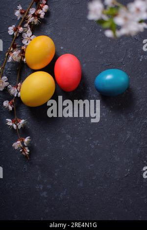 Frisch gebackenes hausgemachtes Osterbrot, natürlich gefärbte Eier und Frühlingsblumen. Stockfoto
