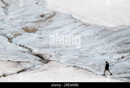 Garmisch Partenkirchen, Deutschland. 25. Juli 2023. Ein Tourist geht vor den Überresten des Gletschers auf der Zugspitze spazieren. Kredit: Peter Kneffel/dpa/Alamy Live News Stockfoto