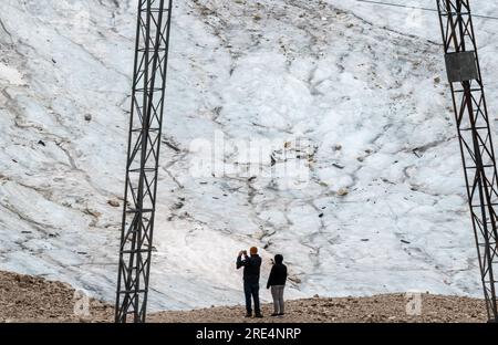 Garmisch Partenkirchen, Deutschland. 25. Juli 2023. Touristen stehen vor den Überresten des Gletschers auf der Zugspitze. Kredit: Peter Kneffel/dpa/Alamy Live News Stockfoto