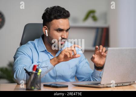 Glücklicher indischer Geschäftsmann bei Online-Videogesprächen oder Meeting auf einem Laptop im Büro - Konzept von Unternehmern, Finanzberatung und Kommunikationsfähigkeiten. Stockfoto