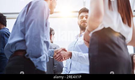 Lachende junge Geschäftsleute, die im Büro reden. Stockfoto