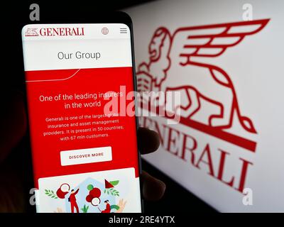 Person, die ein Mobiltelefon mit einer Webseite der Versicherungsgesellschaft Assicurazioni Generali Spa auf dem Bildschirm mit Logo besitzt. Konzentrieren Sie sich auf die Mitte des Telefondisplays. Stockfoto