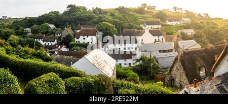 CADGWITH, CORNWALL, GROSSBRITANNIEN - 1. JULI 2023. Traditionelle strohgedeckte Fischerhäuser und Ferienhäuser in dem beliebten Fischerdorf Cadgwith Stockfoto
