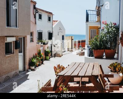 Traditionelle Steinhäuser mit gefliesten Dächern und verschiedene blühende Pflanzen in Töpfen schmücken den Eingang zu den Häusern in der Altstadt. Stockfoto