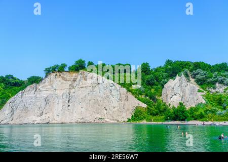 Toronto, Kanada - 23. Juli 2023: Menschen schwimmen am Strand des Ontariosees in Scarborough Bluffs. Der Ort ist Teil eines öffentlichen Parks namens Bluffer's Stockfoto