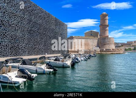 In der Nähe von Marseille liegen Reihen von Schnellbooten vor. Dahinter befindet sich der Steinturm der Tour du Fanal, der 1644 erbaut wurde, um Schiffe in den alten Hafen zu führen. Stockfoto