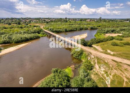 Draufsicht von der Drohne über den Fluss Sluch, die alte Brücke und das Dorf Liukhcha in Rivne, Ukraine. Stockfoto