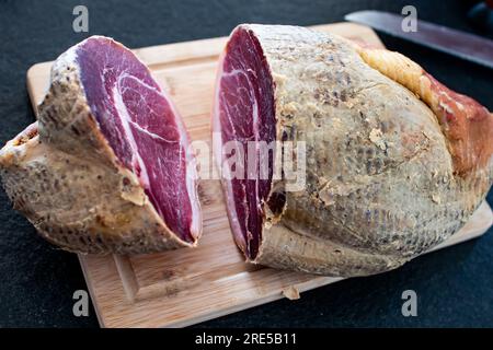 Frischer Schinken, auf einem Holztisch geschnitten. Spezielles, leckeres Essen Stockfoto