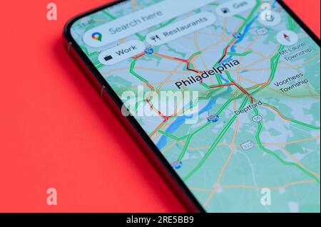 New York, USA - 21. Juli 2023: Autoverkehr auf Philadelphia google Maps auf Smartphone-Bildschirm Nahaufnahme mit rotem Hintergrund Stockfoto