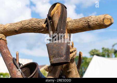 Die alte rostige Kuhglocke hing an einem Holzpfahl Stockfoto