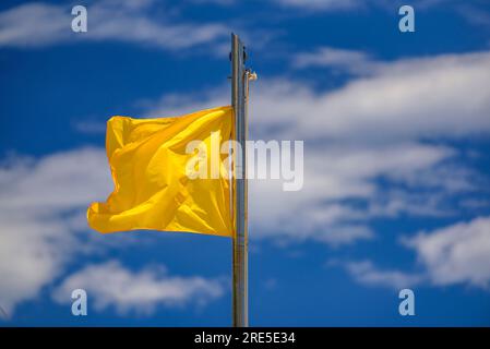 Gelbe Flagge am Strand von Llevant in Salou an der Küste der Costa Daurada an einem Sommertag (Tarragona, Katalonien, Spanien) Stockfoto